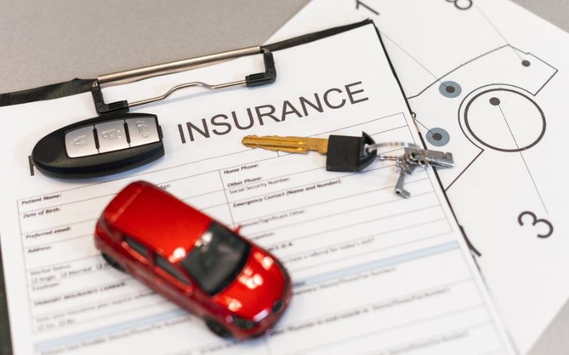 Car insurance policy with set of keys and a toy car