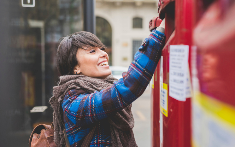 A young woman posting a letter