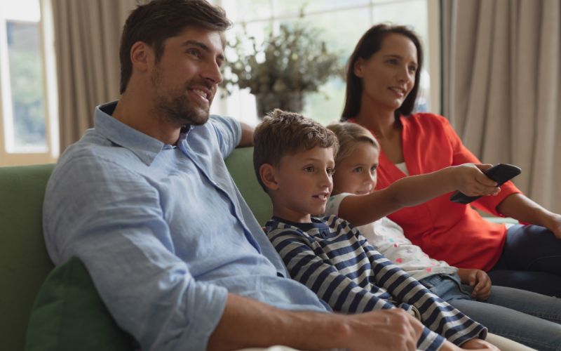 Family of four sitting down watching TV