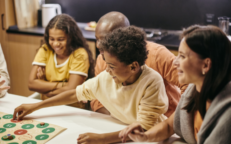 Family seated at a table playing a board game