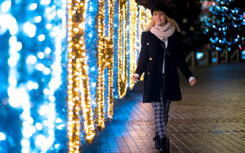 Young woman walking through festive light display